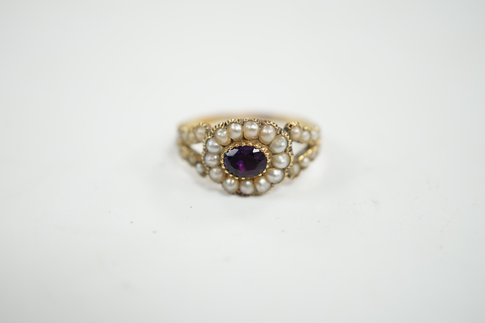 A Victorian yellow metal amethyst and seed pearl cluster set ring, size P/Q, gross weight 3 grams. Condition - poor